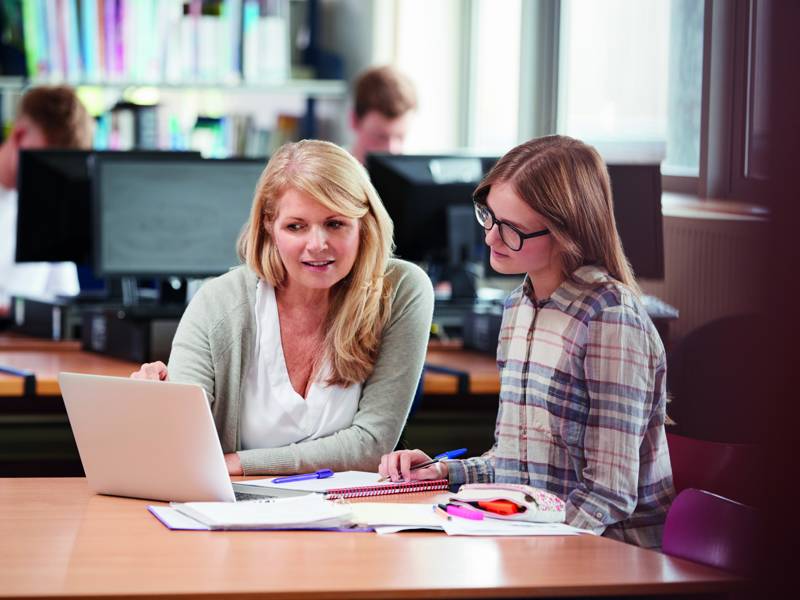 Student support staff sat helping female student
