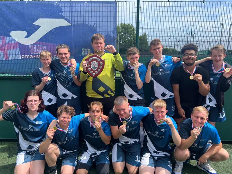 COPC pan disability football team celebrating their league win with their medals