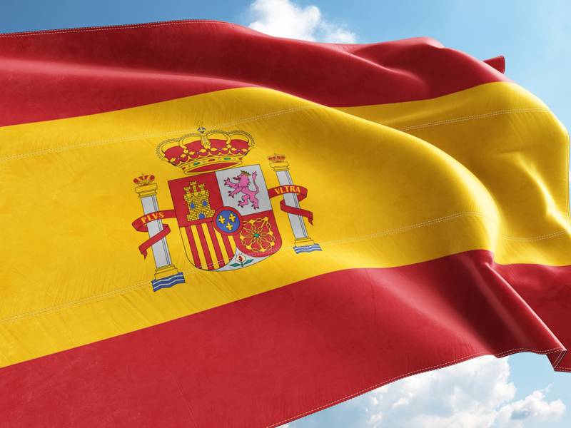 Spanish Flag Waving in the Wind on Flagpole, on sky background