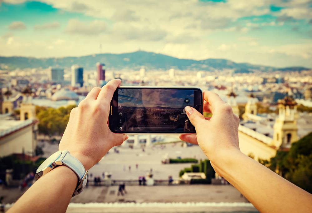First person view taking a picture of a city with a smart phone.