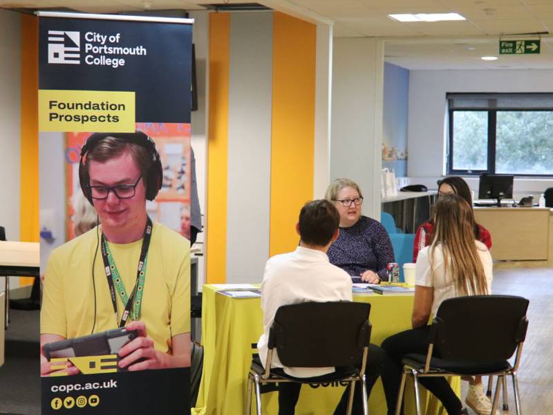 Prospective Students sat at Foundation Prospects desk talking to staff at Open Event.