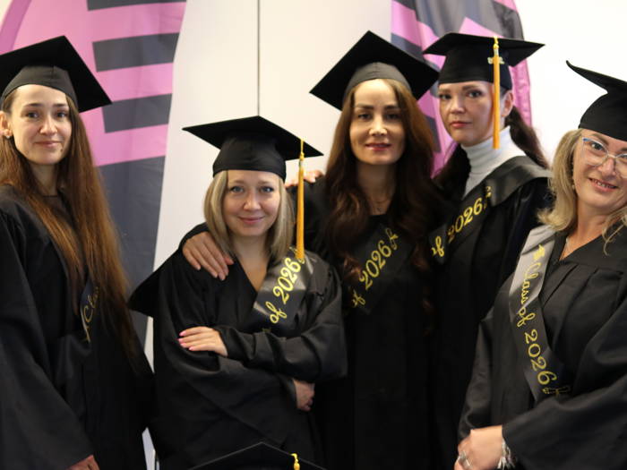 a group of five ESOL level 2 students in their graduation gowns