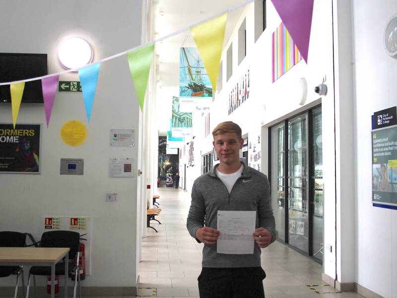Student holding up their results certificate during results day event at Highbury Campus.