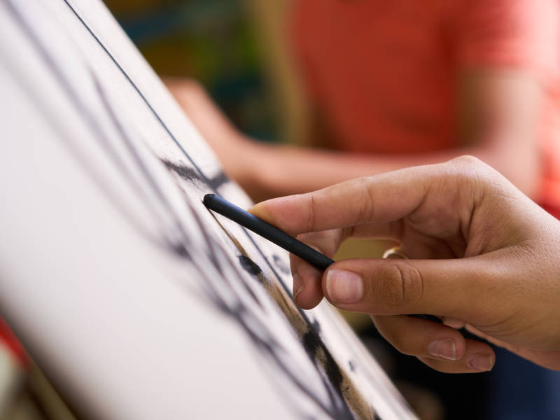 Close up of hand sketching in sketch book.