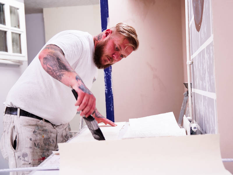 Painting and decorating student works on course work in the workshop at North Harbour Campus