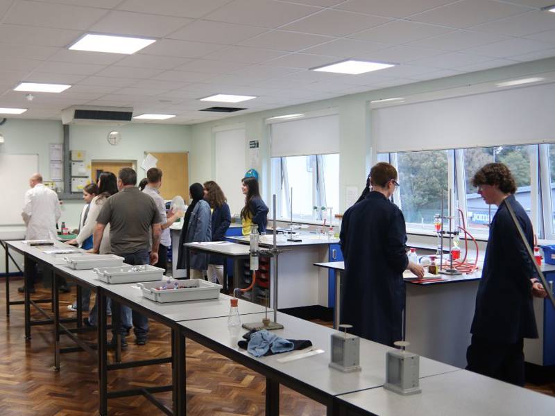Students wearing lab coats in the science labs at Sixth Form Campus.
