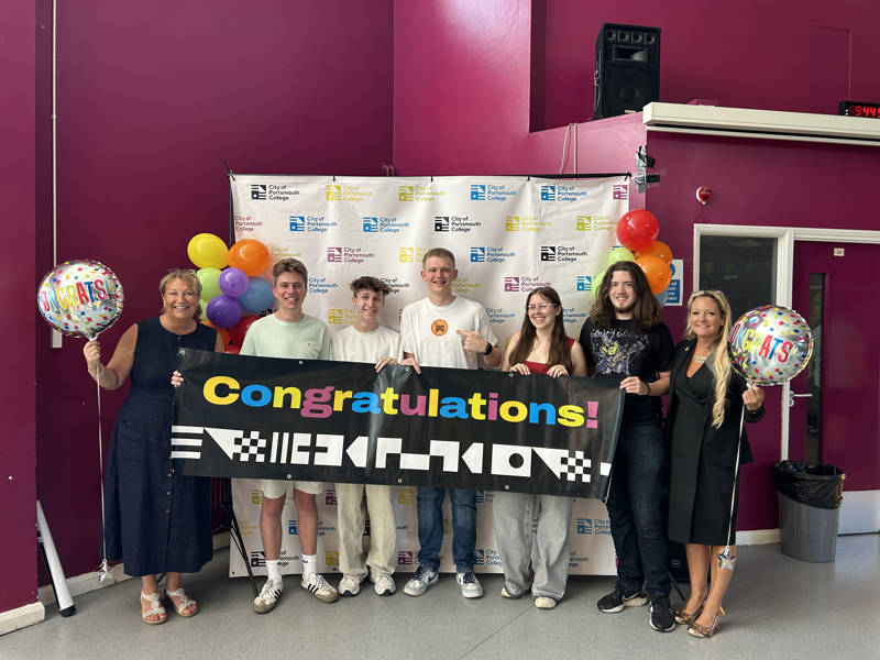 City of Portsmouth College students hold a congratulations banner on A Level results day, accompanied by Katy Quinn, Principal and CEO, on the left, and Portsmouth North MP Amanda Martin, right.